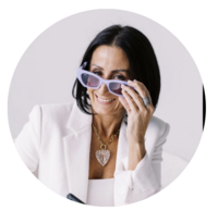Tarah Baiman peeking over her sunglasses and smiling