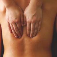 A person receives a relaxing Swedish massage, with the therapist's hands gently working on their back. This calming treatment is available at Bodyology Therapeutic Massage in Boise and Eagle.