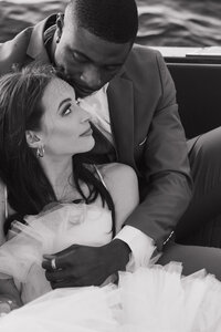 Bride and groom sitting in a car embracing