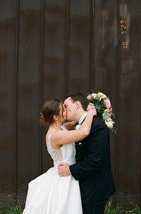 Film image of bride and groom kissing after their wedding ceremony in Minnesota.