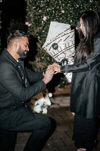 Param proposing to Agampreet at night with a bouquet of flowers, captured in bold direct flash style during their Auckland proposal photoshoot by Zanthe Vorsatz.
