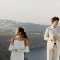 Couple in wedding attire holding hannds on big sur coast