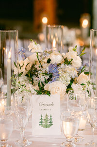 reception table flowers with white roses and glowing candle light at the whiteface lodge wedding