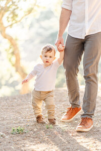 One-year-old girl running towards the camera with a big smile on her face