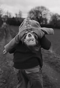 Brother and sister hugging and laughing in black and white image