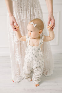 Babyfotoshooting: Babysberste Schritte an Hand festgehalten bei einem Babyfotoshooting.