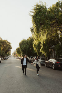 Fiance's holding hands prancing down street