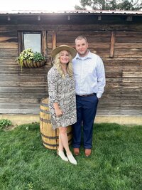 blonde woman in dress and felt hat with man in dress pants and button down shirt