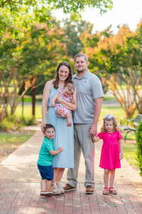 A family poses in a garden in Raleigh, NC by Laramee Love Photography