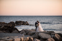 Couple kissing on Newport rocks by ocean