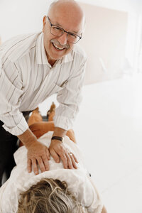 Chiropractor providing their services for a customer in a well-lit office.