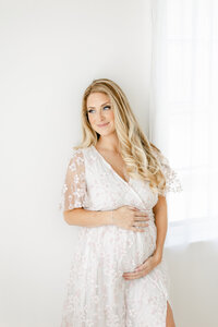 pregnant mom in pink floral dress photographed by south jersey newborn photographer
