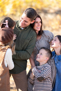 Family laughing in the golden hour light in Logan, Utah