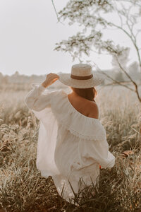 Woman wandering through tall grass in a field