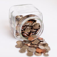 Coins spilling out jar