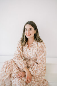 McKenna the artist from life in letters sitting posed with her arms crossed smiling at camera representing full service design and calligraphy by Life in Letters.