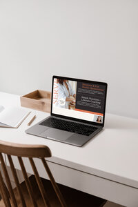 Aubre wearing a white button down shirt standing in front of a sun drenched window