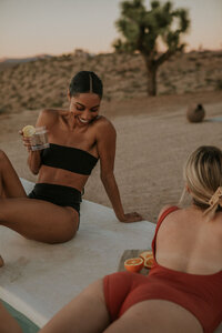 girls laughing on towel in bikinis