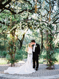 Bride and groom kiss at ceremony altar