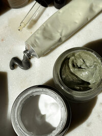 Skincare products in jars, a tube, and dropper bottle