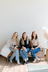 Team members of Lavender & Ink Studios sitting together, showcasing hype-woman energy and supportive culture