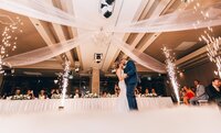 Wedding guests dance underneath ambient market lighting