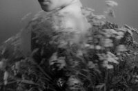 blurred woman with flower infront of her - black and white