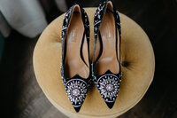 Up-close image of black suede heels embellished with beads