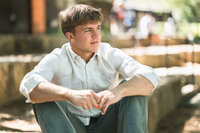Senior girl in beautiful flowers and sunlight