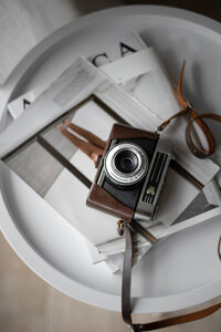 Overhead photo of silver shoes and printed images on the floor in soft natural light, evoking a poetic creative process.