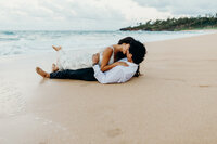 bride & groom laying on the beach