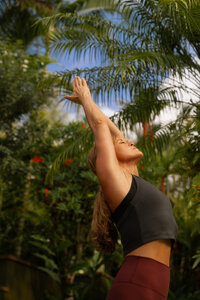 Nicole performing an arm-strengthening Pilates pose outdoors in Kauai, building muscle awareness at Love Light Wellness.