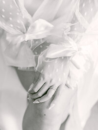 Close-up of bride's hand with lace wedding dress