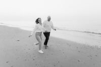Bridesmaids wearing elegant black dresses holding white flwoer bouquets.