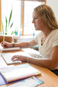 Amy sitting in her office writing in a notebook