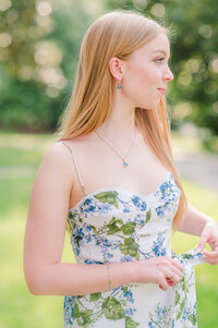 a young girl posing in a blue and green floral dress