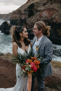 bride and groom cliff side looking at each other lovingly