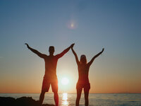 Couple celebrating at sunset from honeymoon testimonial about balanced adventure and relaxation. Tailored Oasis Travel Co.