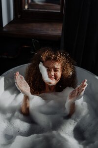 Happy girl in bathtub with bubbles