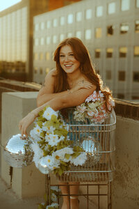 Golden hour portrait session with disco balls, florals, and a shopping cart on a rooftop garage in downtown Abilene, TX