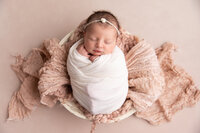Newborn girl with pink bonnet and knit outfit