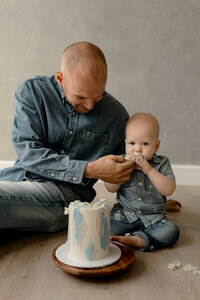 dad sharing with baby's 1st birthday cake