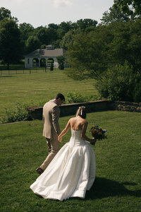 bride and groom sitting on park bench, bride in white wedding dress, groom in black tie and tuxedo, wedding photographer