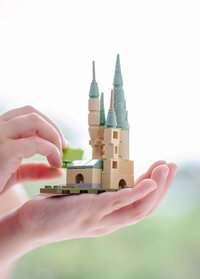 lego hogwarts castle held up in the air by a child's hand