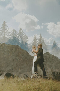 bride and groom embracing each other with a double exposure of trees overtop