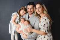 family posed on dark grey backdrop in Hamilton, ON