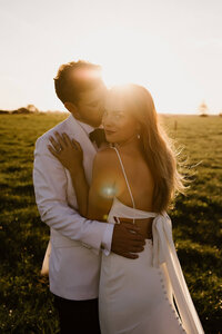 Kaitlyn and Zac holding each other while taranaki wedding photographer aimee kelly photographs them