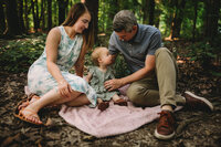 Family photoshoot with mom, dad, and baby outside.