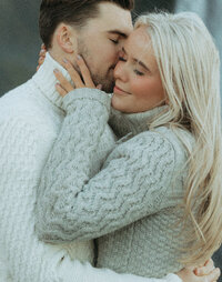 Romantic engagement photo of a couple in cozy sweaters, captured by a Utah wedding and elopement photographer.