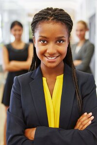 Professional young intern woman smiles confidently at the camera.